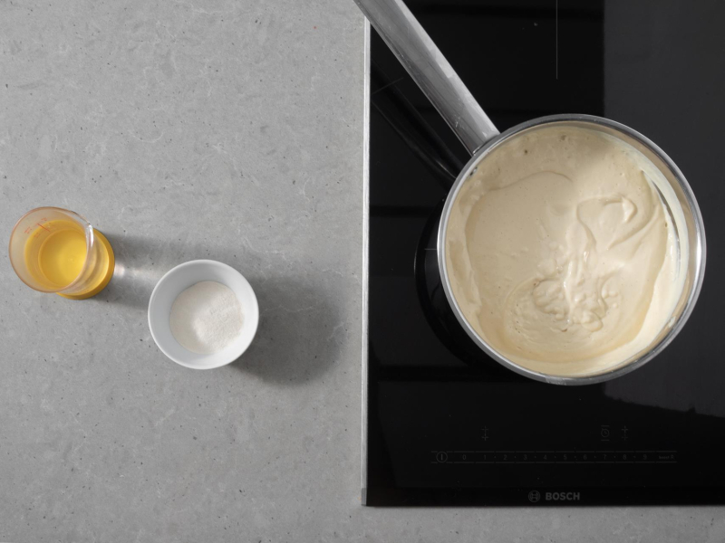 W garnku masa tofurnikowa. Obok w miseczce agar i woda.