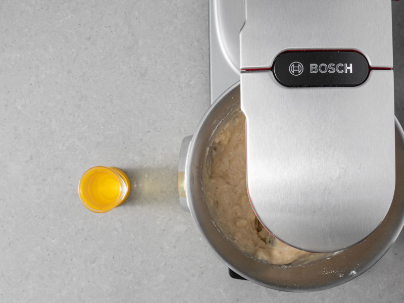 Ucieranie ciasta w robocie kuchennym Bosch. Obok olej w miarce.