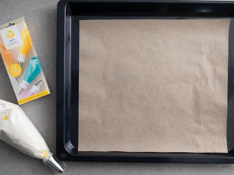 na blacie forma z piekarnika obok worek z tylką wypełniony masą bezową