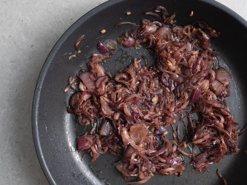 Skarmelizowana czerwona cebuli na patelni.