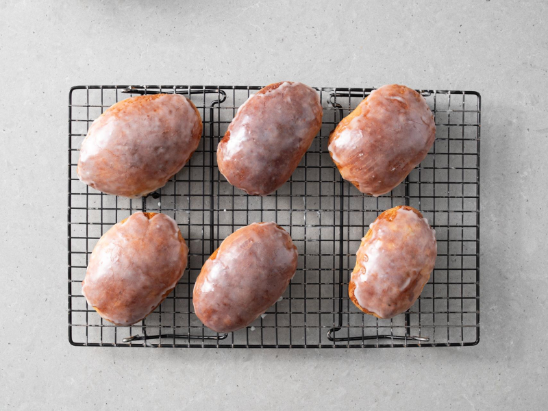 Posmarowane lukrem jagodzianki na kratce do studzenia.