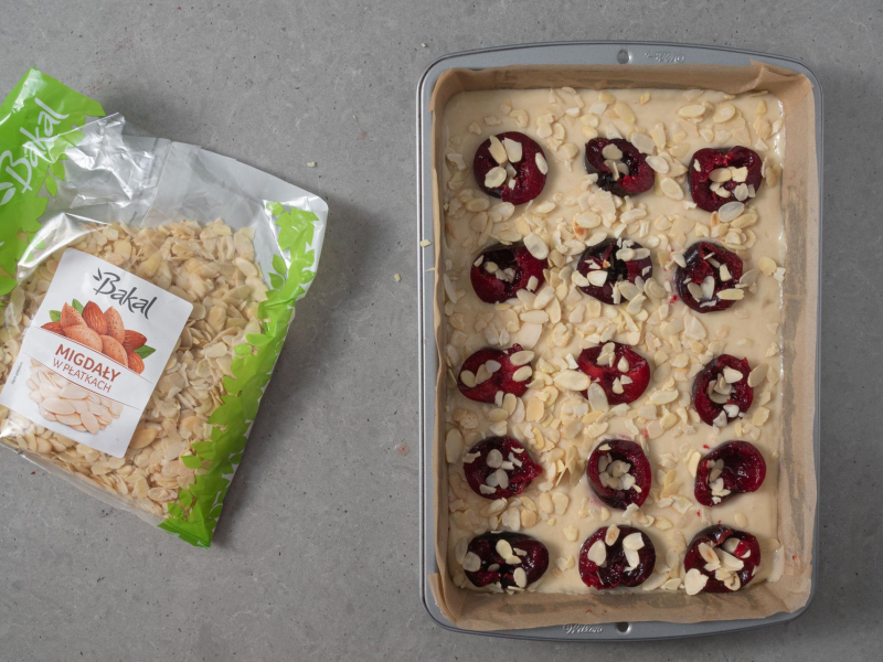 Ciasto bez jajek przed upieczeniem. Obok płatki migdałów.