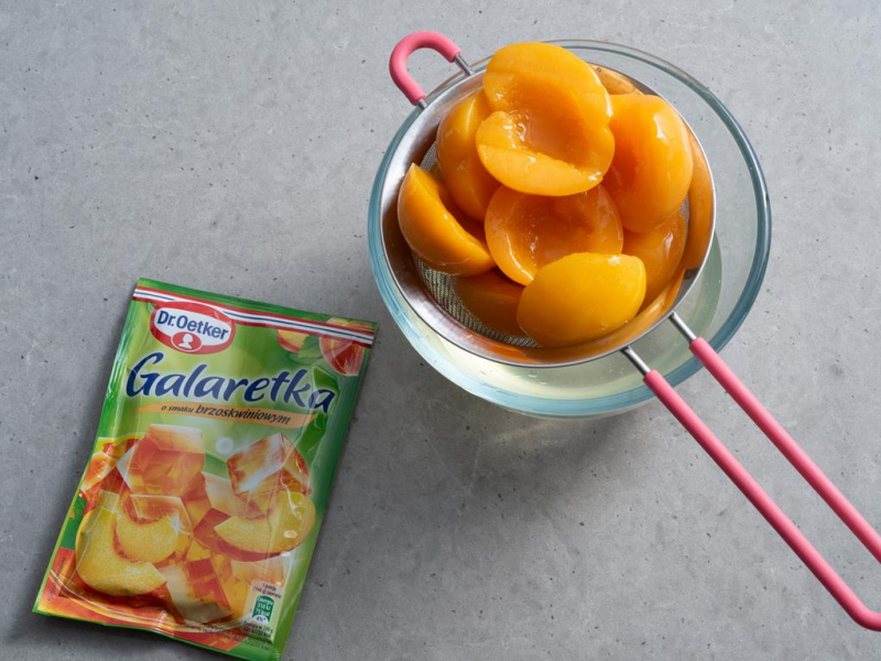 na sitku odcedzone brzoskwinie z puszki i galaretka brzoskwiniowa dr. oetkera
