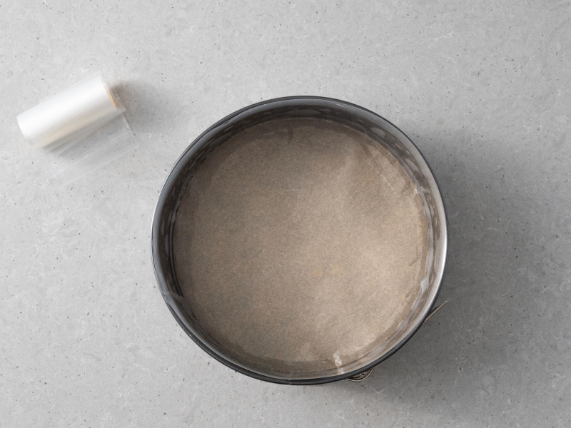 Na blacie kuchennym folia rantowa oraz forma wyłożona papierem do pieczenia.