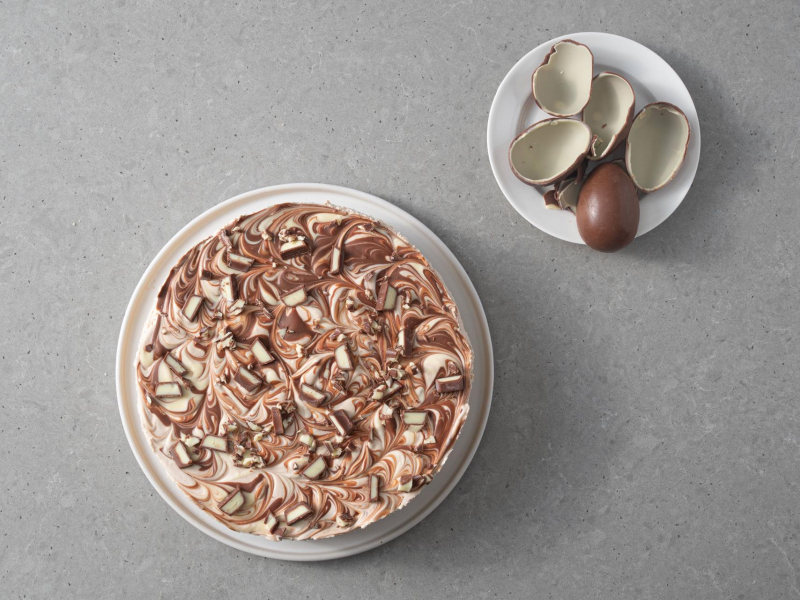 Gotowe ciasto kinderkami. Obok jajeczka czekoladowe kinder