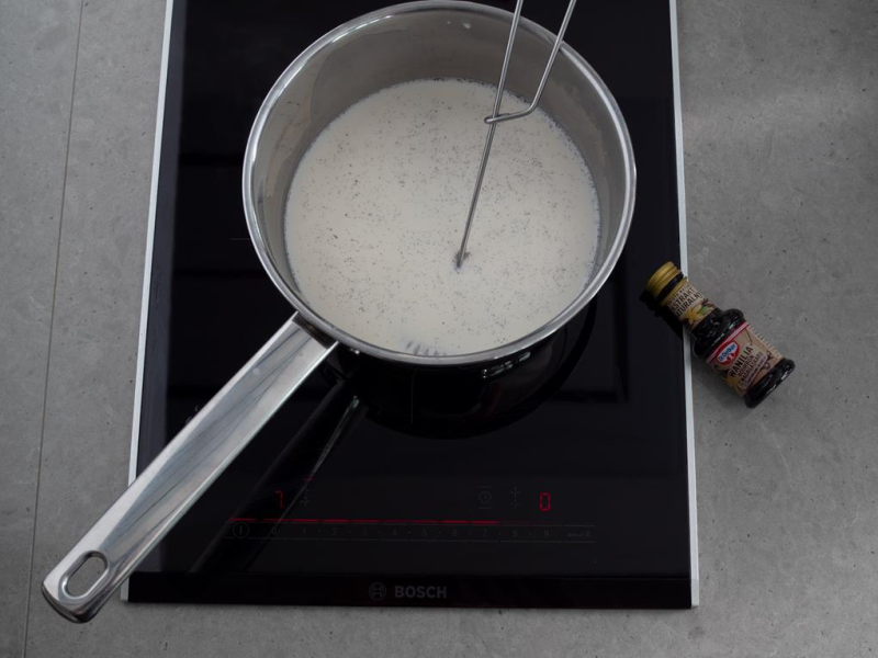 w rondelku gotujące się mleko z ekstraktem z wanilii dr. oetkera