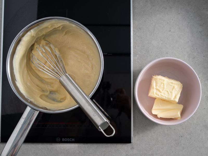 w rondelku na płycie krem patissiere obok miękkie masło w miseczce