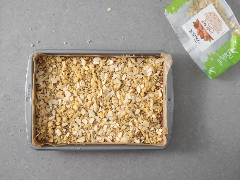 Szarlotka z kruszonką i płatkam migdałów przed pieczeniem.