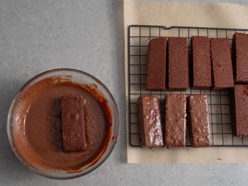 w misce polewa czekoladowa i moczone w niej kawałki ciasta
