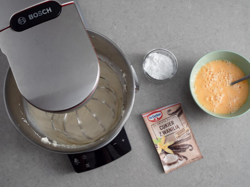 w misie robota bosch masa serowa, na blacie miseczka z jajkami i cukier z wanilią Dr. Oetkera