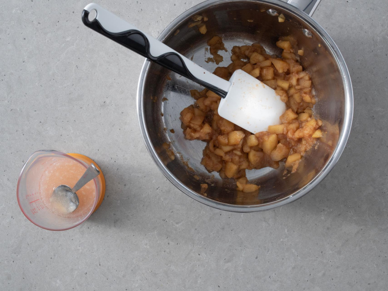 W garnku podprażone jabłka. Obok w miarce wymieszana woda z pektyną.
