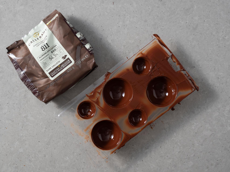 Na blacie czekolada ciemna callebaut 811, a obok forma plastikowa.