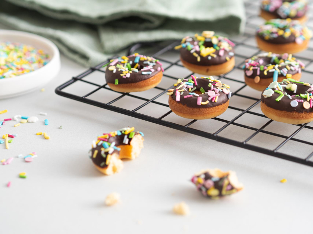 Pieczone mini donuty na kratce do studzenia, w polewie czekoladowej z cukrową posypką - Wszystkiego Słodkiego
