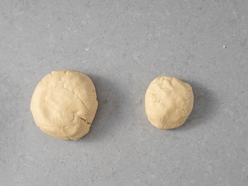 Dwie części ciasta kruchego do wegańskiej szarlotki z budyniem.