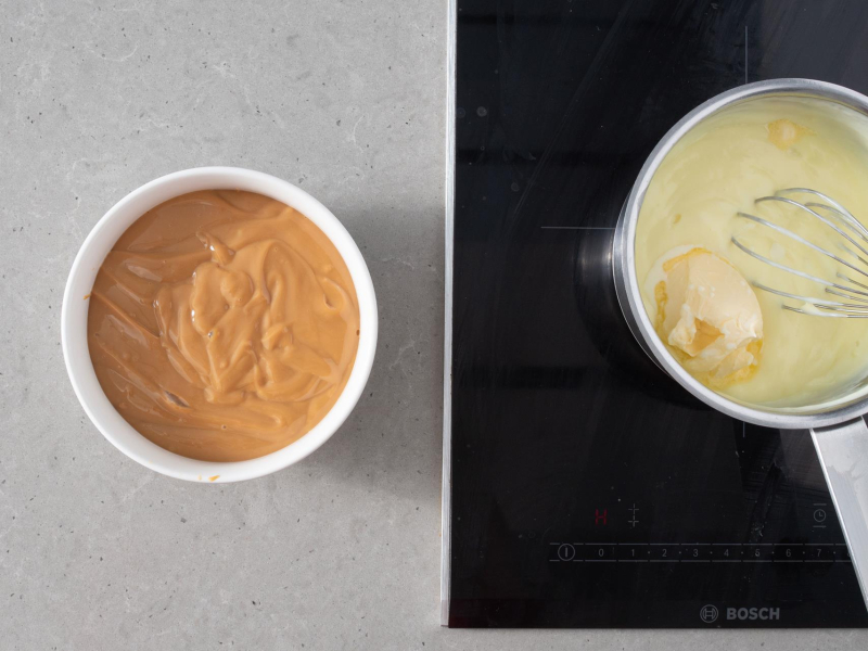 W miseczce kajmak. Obok budyń z masłem w garnku.