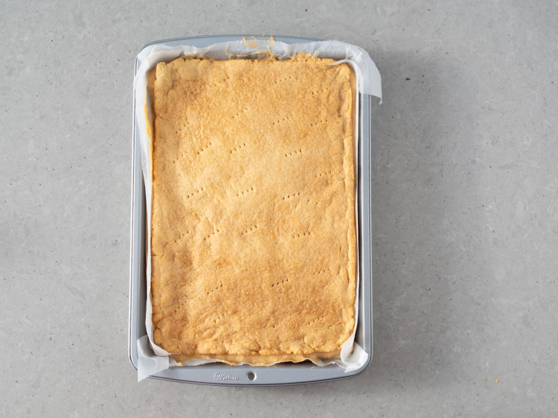 Budyń z kajmakiem przykryty ostatnim blatem ciasta.