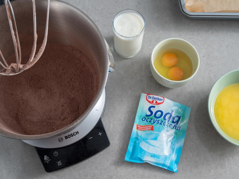 w misie bosch suche składniki na ciasto czekoladowe, obok soda wybite jajka w miseczce
