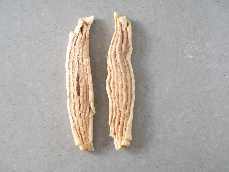 Przekrojone zrolowane ciasto drożdżowe na pół.