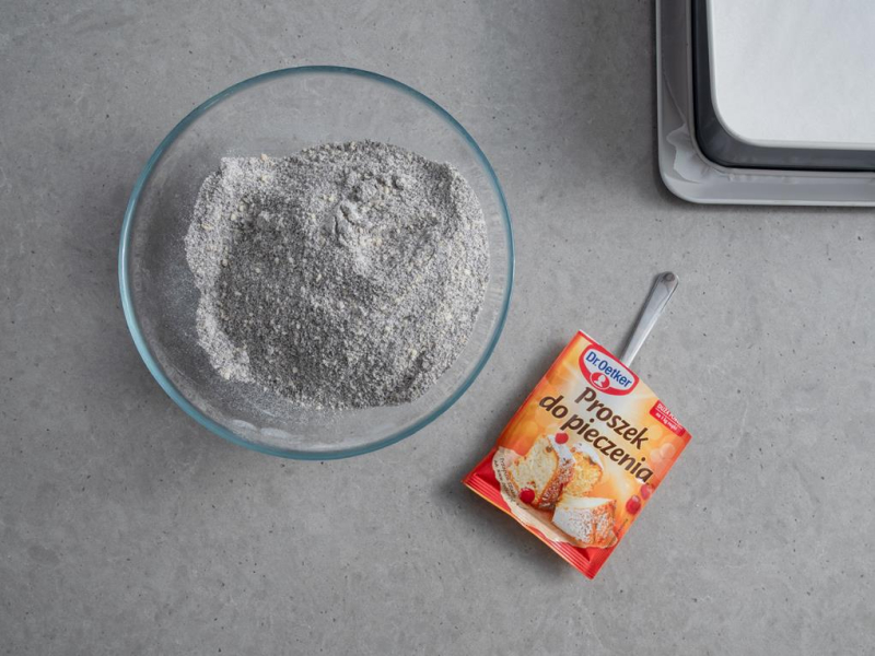 w misce suche składniki na biszkopt z makiem obok proszek do pieczenia