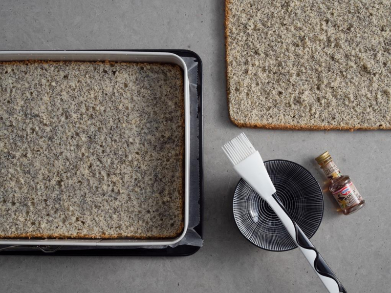 przekrojony na dwa blaty biszkopt z makiem obok poncz z ekstraktem waniliowym Dr.Oetkera