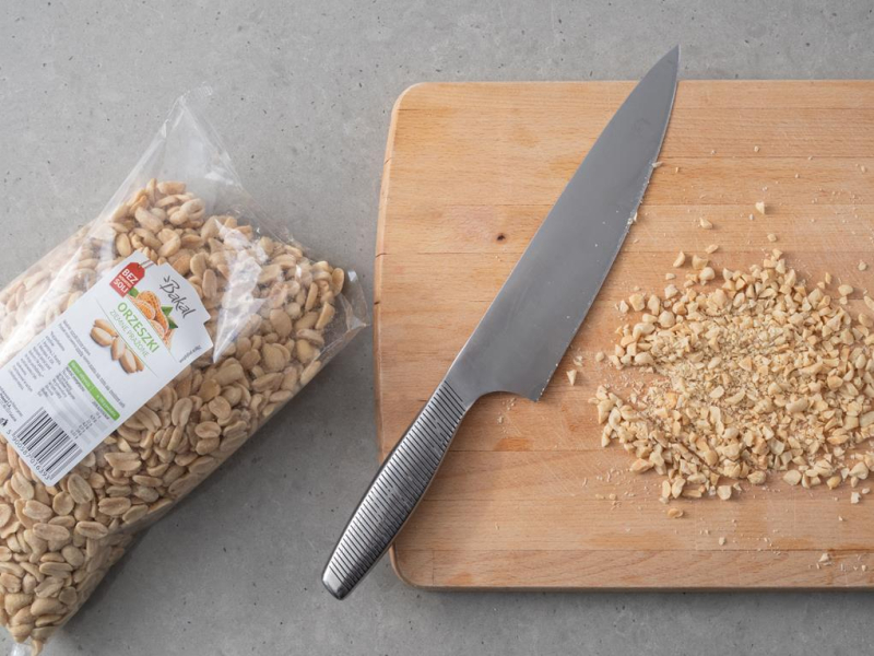 orzeszki ziemne niesolone Bakal krojone na drewnianej desce