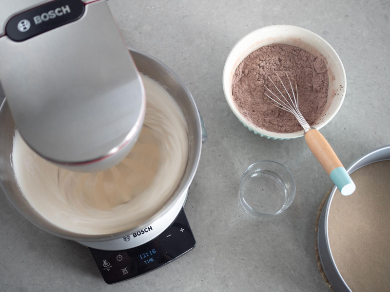 jajka ubite z cukrem w misie miksera, obok miseczka z suchymi składnikami