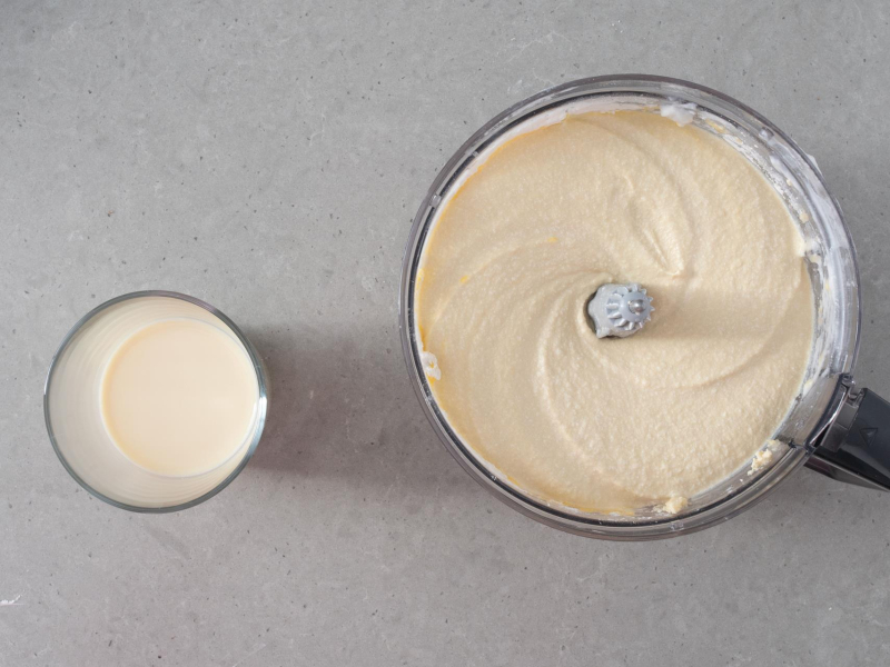 Zblendowana masa tofurnikowa oraz napój sojowy w szklance.