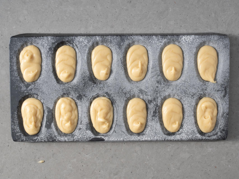 Wyszprycowane ciasto do formy na magdalenki.