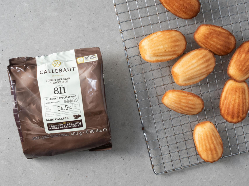 Upieczone magdalenki na kratce do studzenia. A obok czekolada callebaut 811.