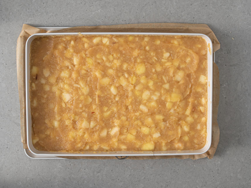 Uprażone jabłka z cukrem i cynamonem, przełożone do prostokątnej formy.