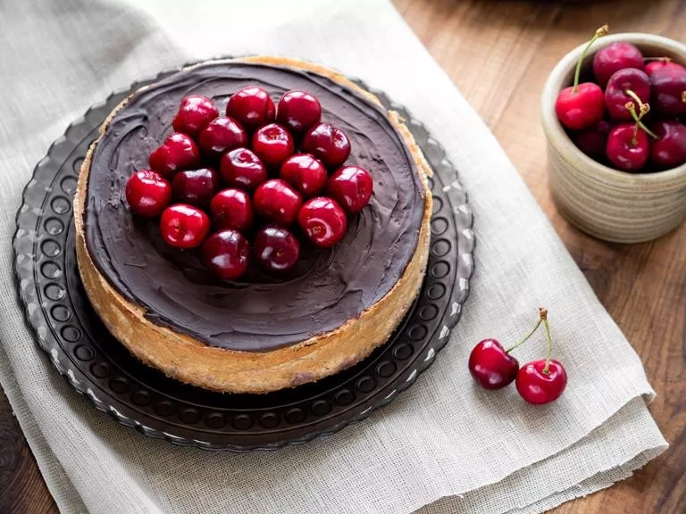 tofurnik oblany czekoladą, na wierzchu świeże czereśnie