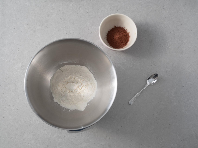 W misie mąka pszenna, a w drugiej misce kakao. Obok sól na łyżeczce.