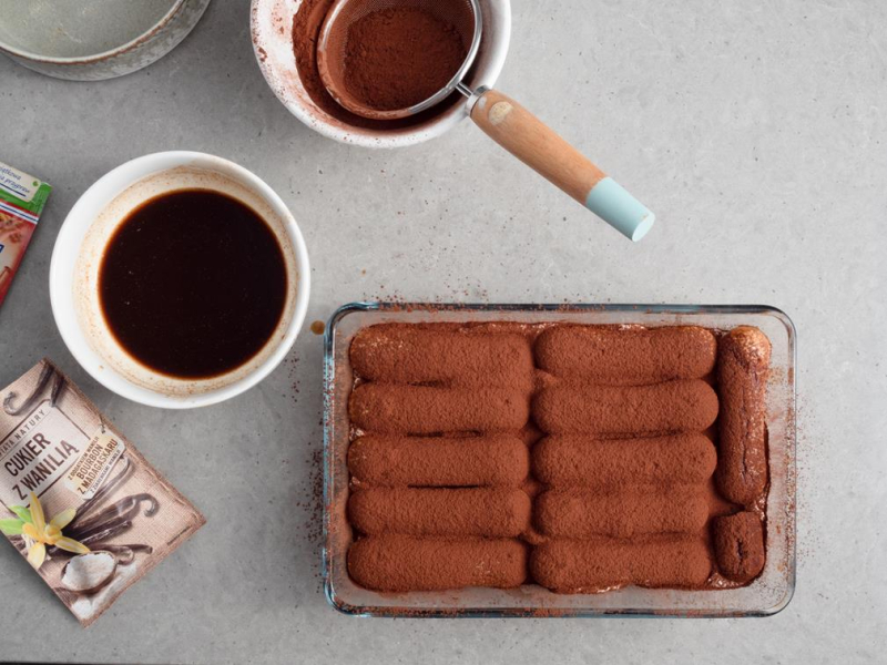 w naczyniu tiramisu z posypanymi kakao biszkoptami