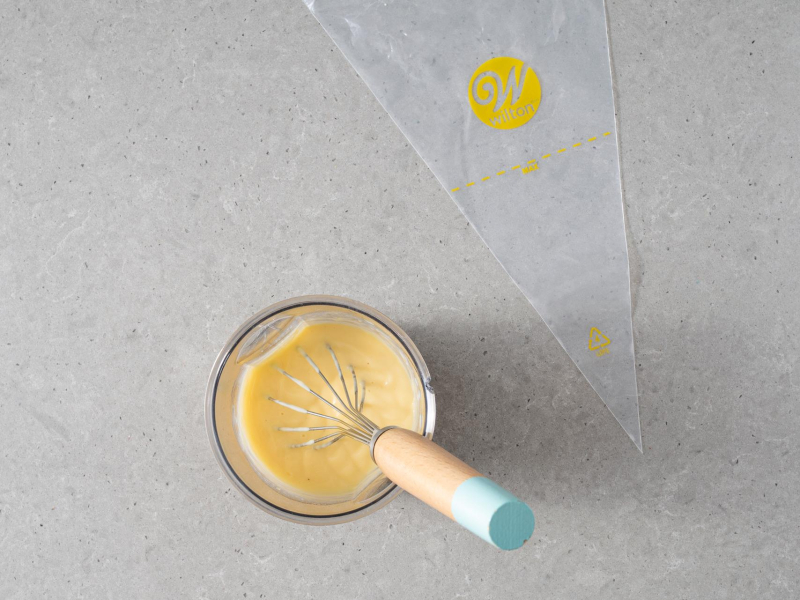 Worek cukierniczy Wilton,  a obok sos waniliowy.