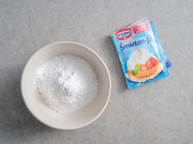 w miseczce cukier puder wymieszany z śmietan fixami dr. oetkera