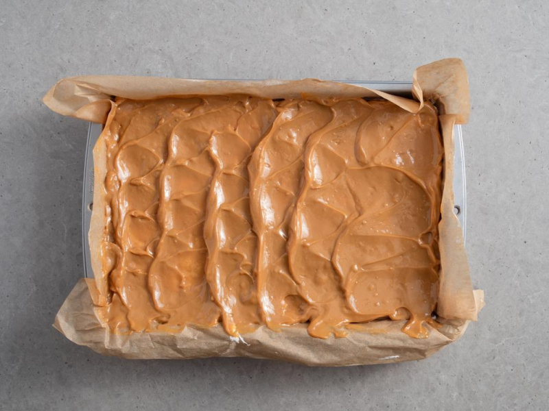 w formie ciasto snikers w masą kajmakową na wierzchu