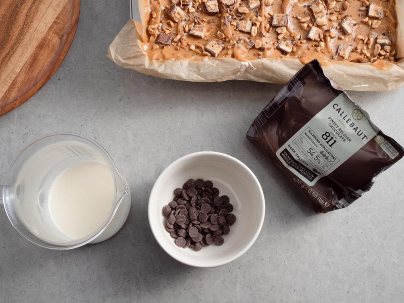 ciasto sniekers i przygotowywana polewa czelkoladowa