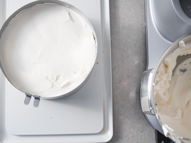 W misie krem śmietankowy. Obok biszkopt przełożony kremem.