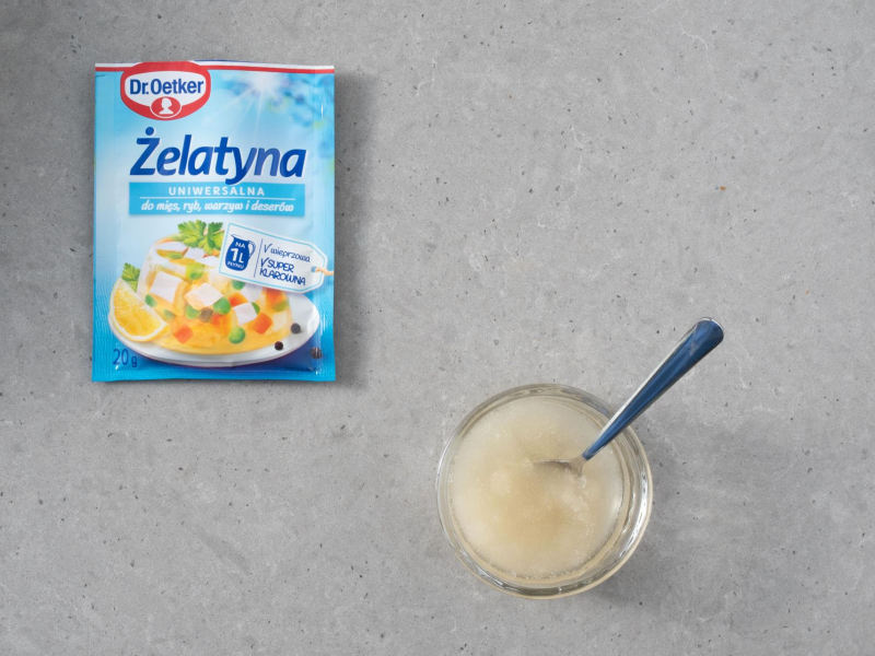 Opakowanie żelatyny uniwersalnej, a obok w miseczce napęczniała żelatyna z wodą.