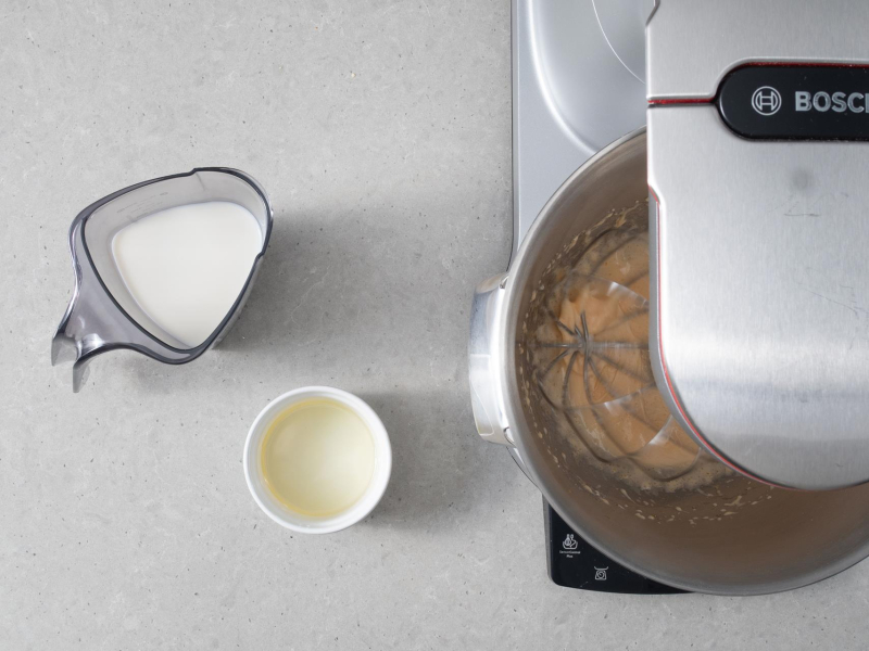 W miseczce olej i w karafce mleko. Obok utarte żółtka z cukrem.