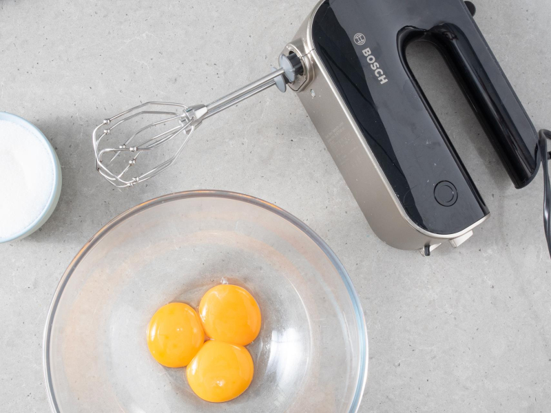 W miseczce żółtka. Obok mikser ręczny firmy Bosch.