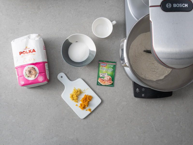 Na blacie kuchennym suche składniki potrzebne do przygotowania ciasta drożdżowego.