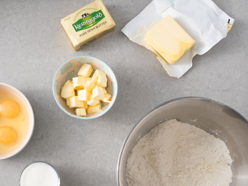 Na blacie kuchennym masło, jajka, ciepłe mleko oraz wymieszane suche składniki.
