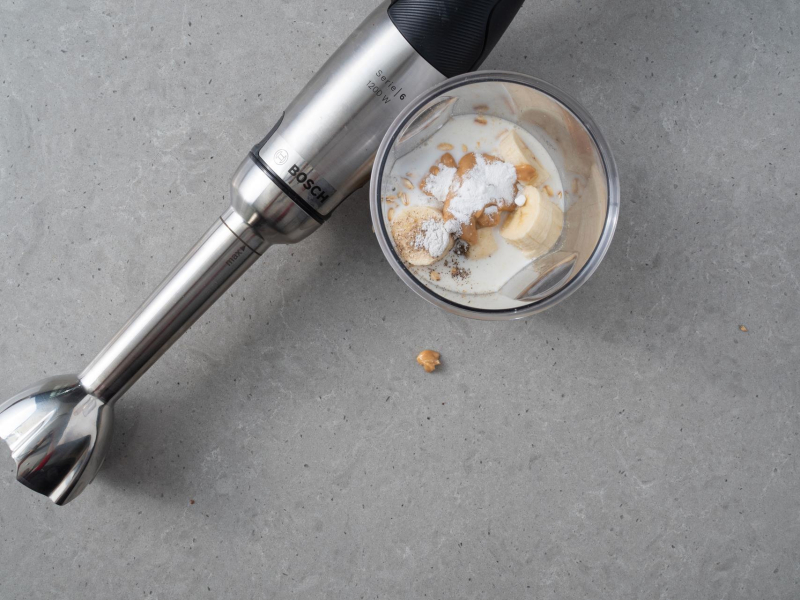 Blender ręczny Bosch na blacie. Obok składniki do zmiksowania.