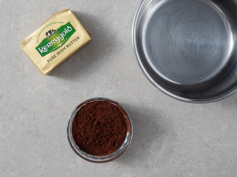 w rondelku składniki na masę czekoladową obok masło Lurpak