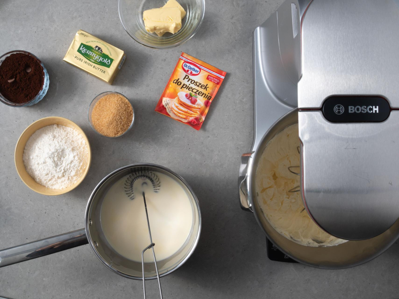 w misie robota ubite jajka z cukrem obok składniki na ciasto kakaowe, masło kerrygold i proszek do pieczenia dr. oetkera