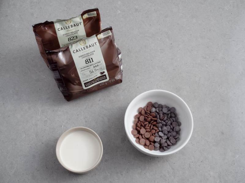 w miseczce kaletki czeloady Callebaut obok śmietanka w miseczce