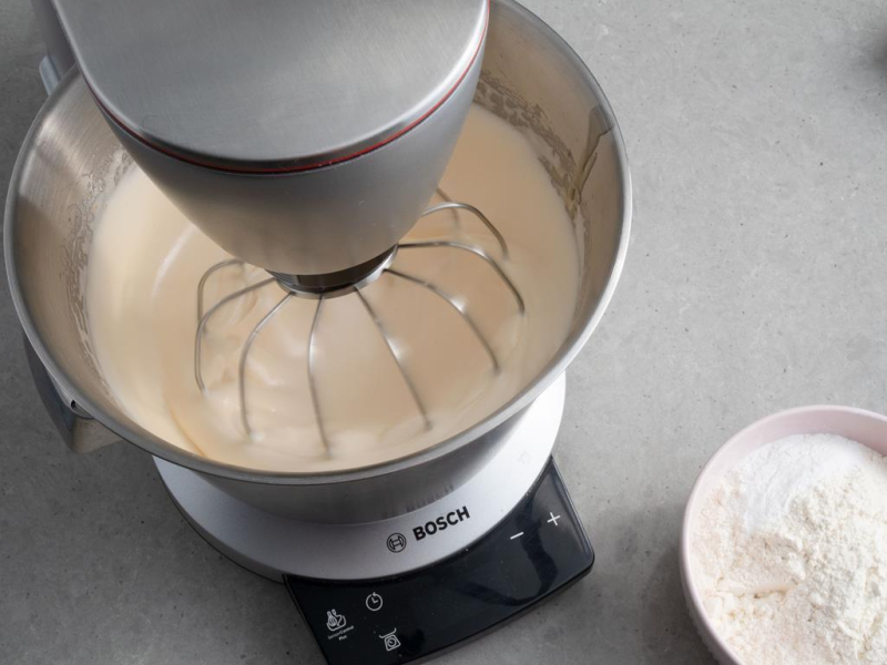 W robocie kuchennym piana z jajek obok miseczka z mąką