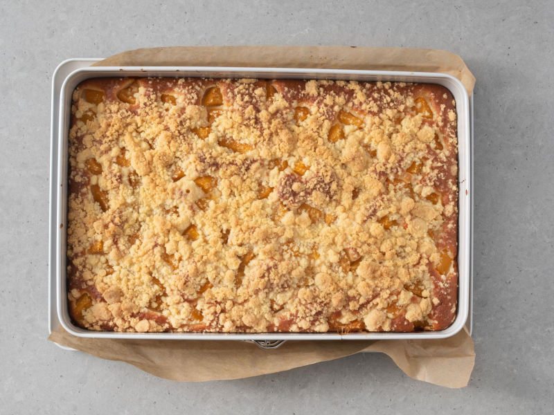 Upieczone ciasto jogurtowe z brzoskwiniami i kruszonką.