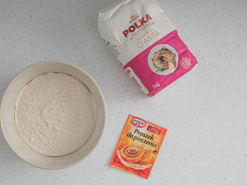 W misce mąka, obok opakowanie mąki i proszku do pieczenia.